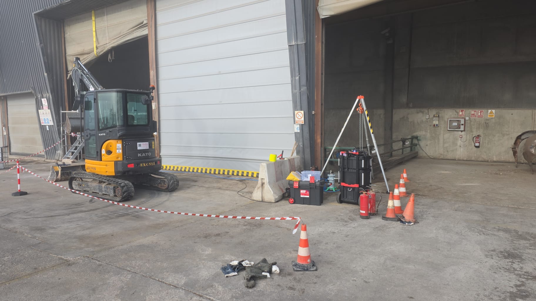 Miniexcavadora en trabajos de espacio confinado en nave industrial